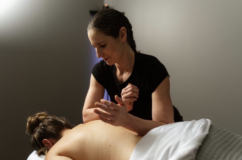 Vivian working along a client's upper back during a session